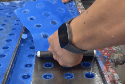 mano cortando la cera sobrante en los moldes fábrica de velas y aromas